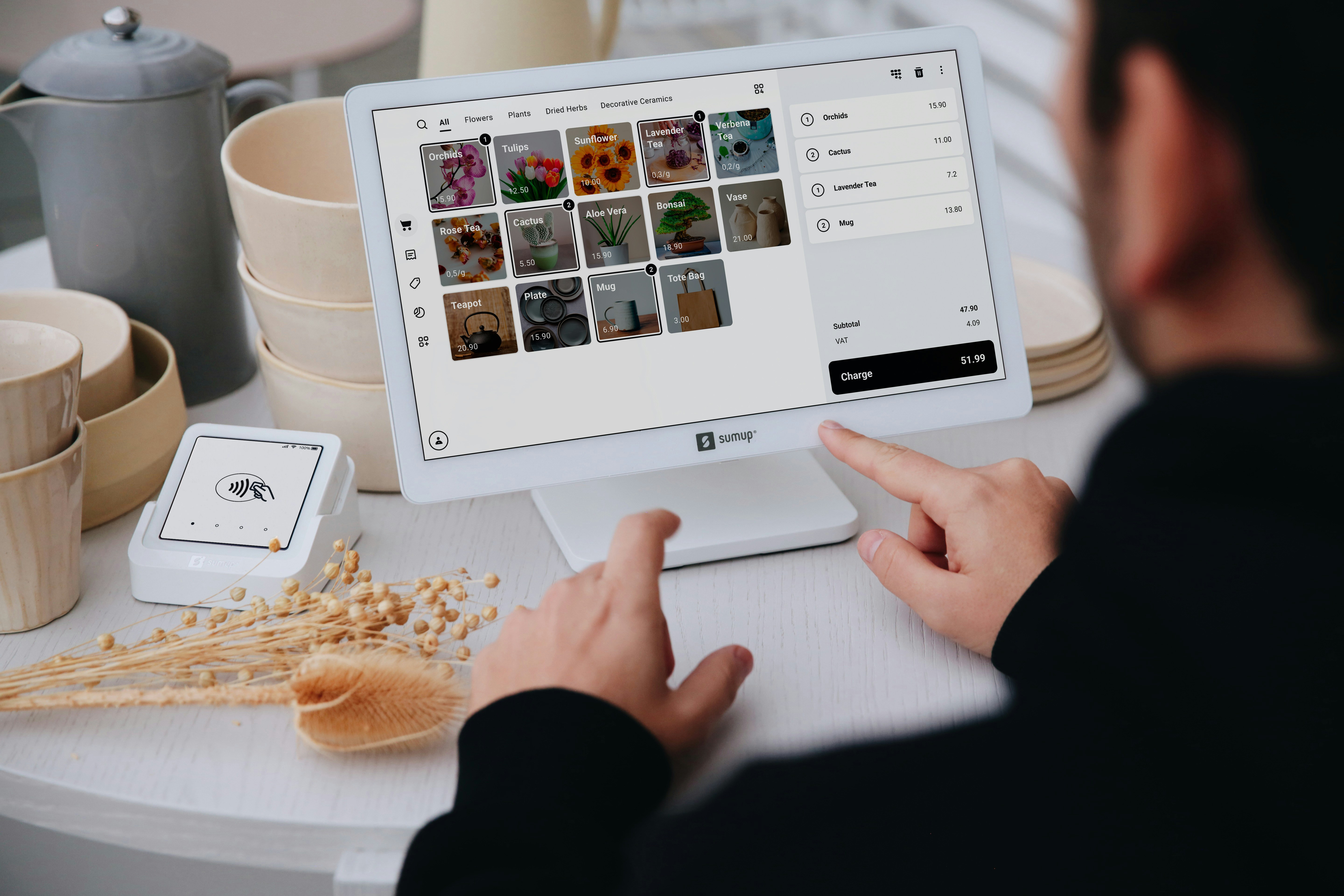 Cashier using modern Tablet POS System at a coffee shop counter